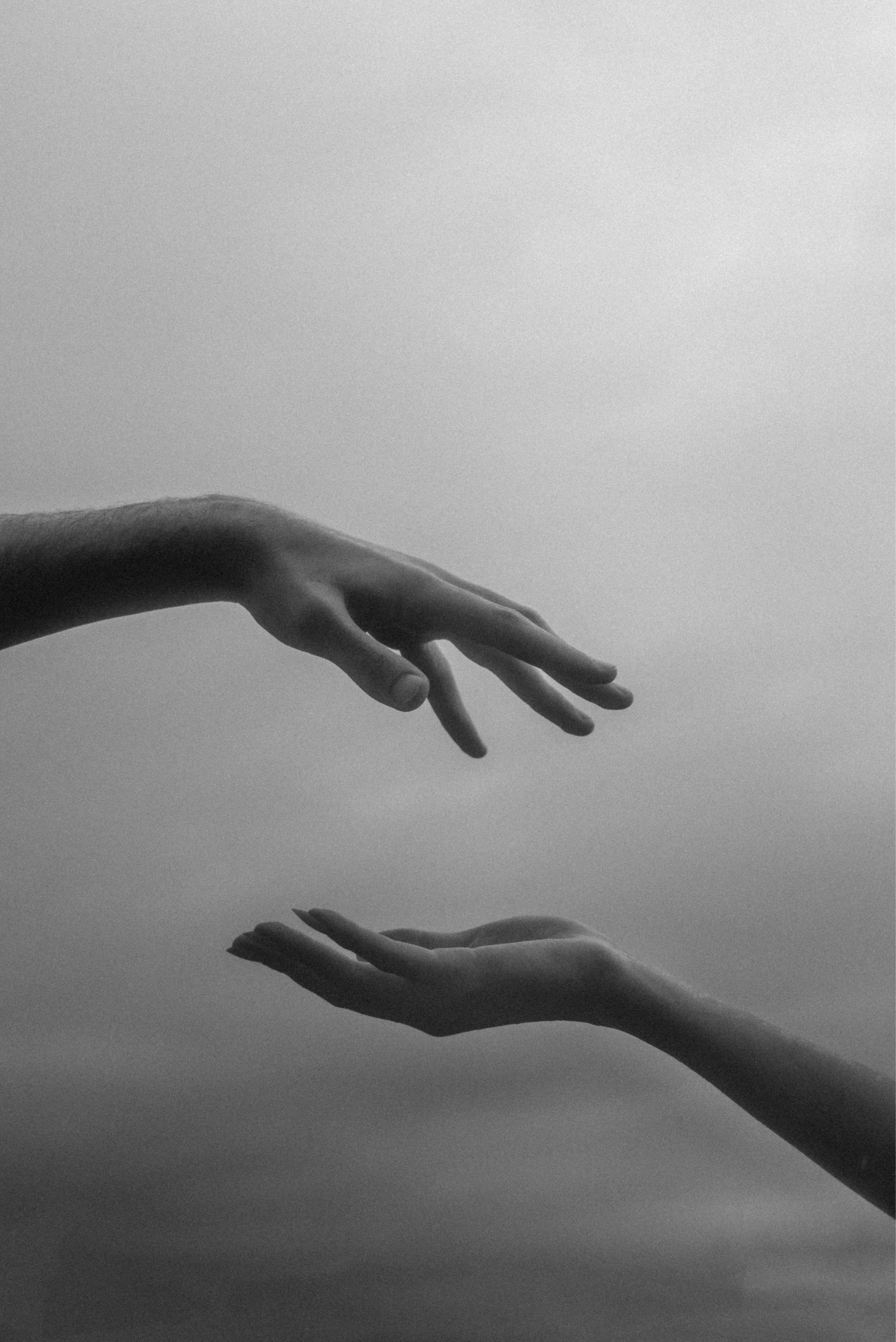 Two hands reaching toward one another
