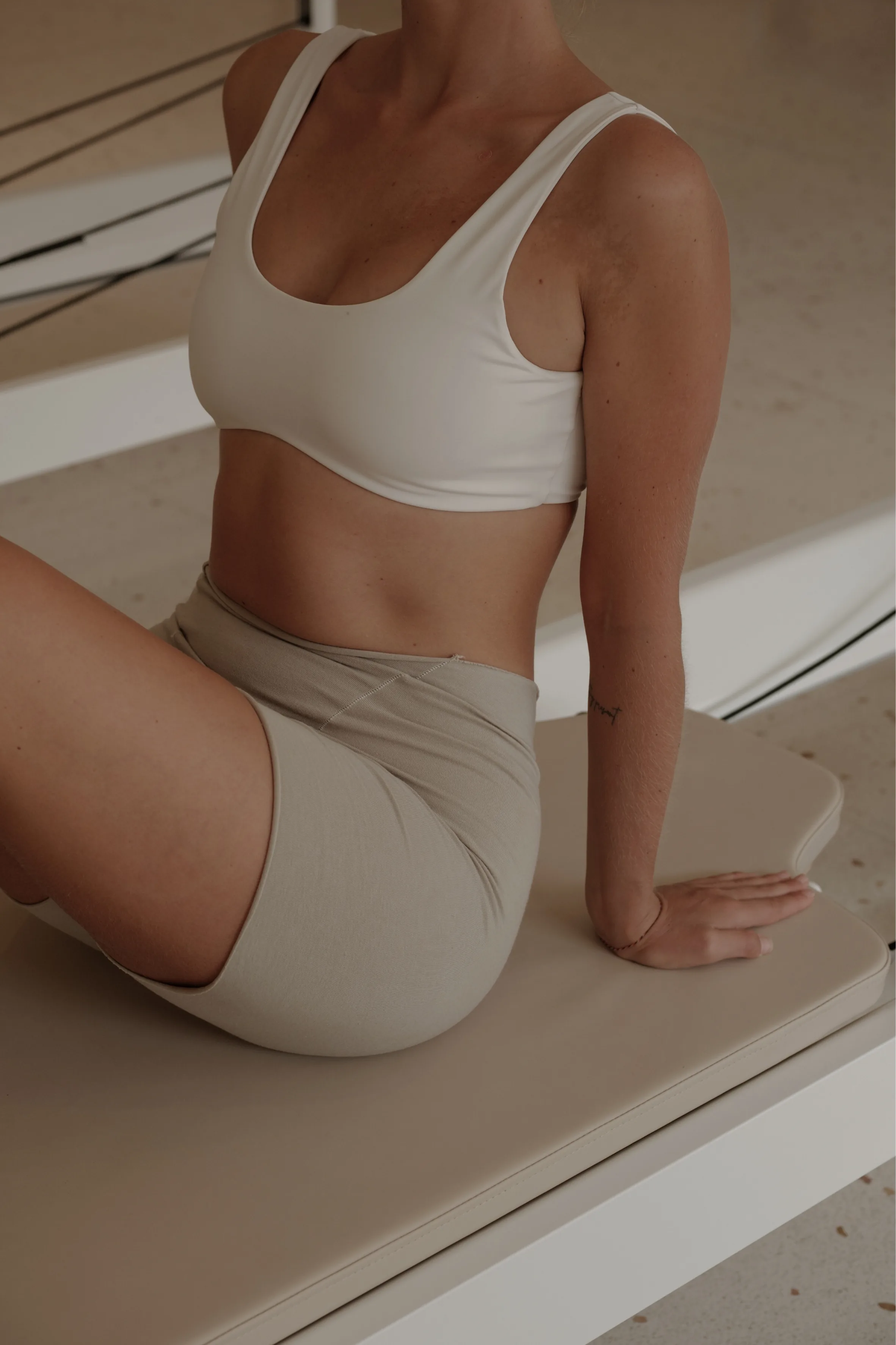 A person wearing neutral activewear in a wellness studio